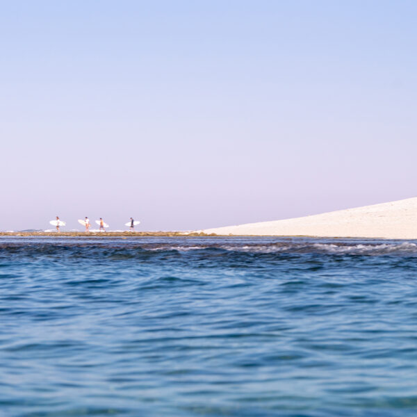 Aerial ocean lifestyle photography showing a traditional fishing boat floating on calm water at sunset in Rote, Indonesia