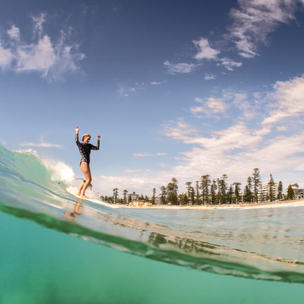 Beautiful Longboard lady sliding down a glassy wave at Manly beach - split level photography - ocean art